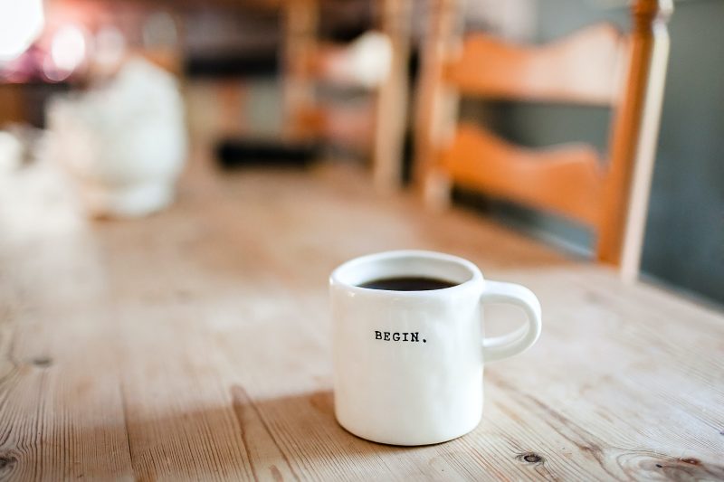 A white cup with begin written on it